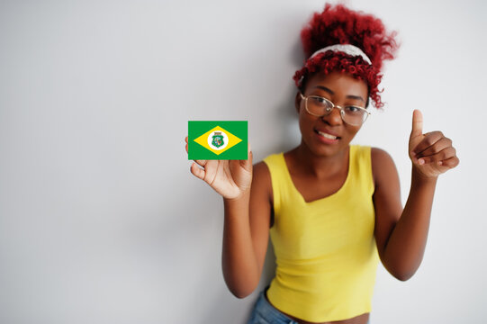 Brazilian woman with afro hair hold Ceara flag isolated on white background, show thumb up. States of Brazil concept.