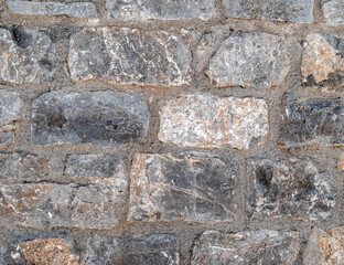 grey and brown stone wall closeup, rough pattern background