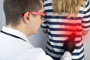 A therapist examines a patient who complains of kidney pain. The doctor will palpate to find out the source of the pain