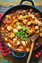 Chicken paneer with indian spices. Chicken pieces with yellow pepper in tomato sauce, parsley. 