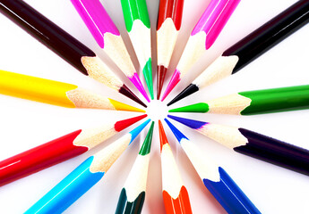 Colored pencils on a white background in the form of a circle close-up. The colors of the rainbow