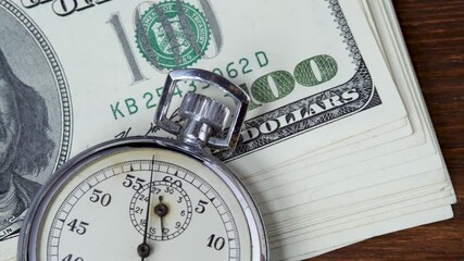 One hundred american dollars bills with analogue metal stopwatch. Counts time in business. Brown wooden background - Powered by Adobe