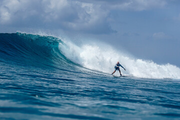 Surfer on perfect blue aquamarine wave, empty line up, perfect for surfing, clean water, Indian Ocean .
