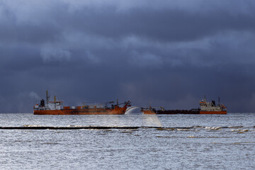 Fototapeta premium Vessel engaged in dredging. Dredger working at sea. Ship excavating material from a water environment.