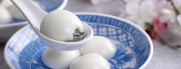 Close up of tangyuan yuanxiao in a bowl on gray table, food for Winter Solstice.