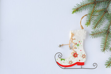 Flat lay composition wooden toy boot skates with christmas tree on white background. Christmas and winter concept. Copy space