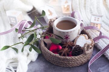 Obraz na płótnie Canvas a cup of coffee, Christmas decorations, gingerbread cookies, ribbon, mistletoe sprigs, knitted white scarf. Greeting card for new year, Christmas.