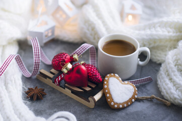 a cup of coffee, Christmas toys, gingerbread cookies, ribbon, toy wooden sled, knitted white scarf. Greeting card for new year, Christmas.