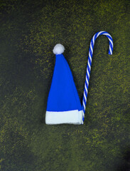 Christmas dark background. Blue cap of Santa Claus.