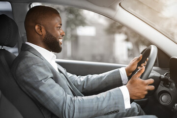 Joyful black businessman driving home after working day