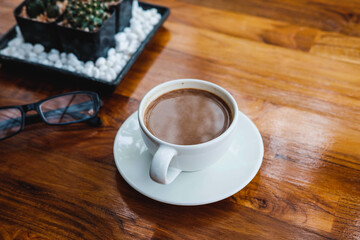 .A cup of coffee on a wooden table in a coffee shop