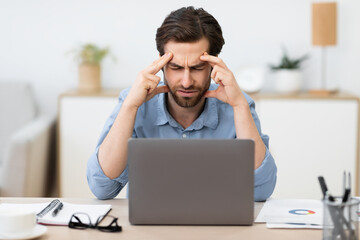 Unhappy Businessman Suffering From Headache Pain Sitting In Office