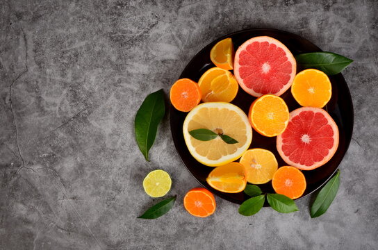 Cut citrus on a plate, Various citrus fruits, Citrus on a concrete background, copy space © SHARKY PHOTOGRAPHY