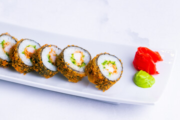 Tempura roll with shrimp in a white plate isolated on white background close up.