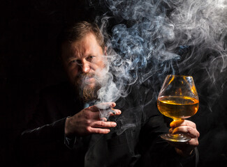 Solid confident bearded man in suit with glass of whisky and cigar with fume