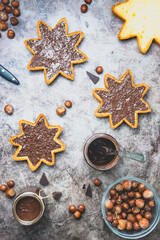 Homemade hazelnut chocolate butter in a jar and spread on star shaped pieces of pandoro panettone.