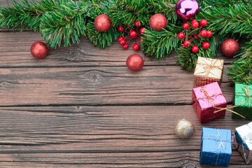 Christmas background decorated with pine trees with gift boxes red blue green yellow and old dark wooden table background decoration top view with copy space