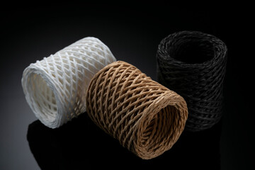 
Three multicolored spools of thread on a gradient background