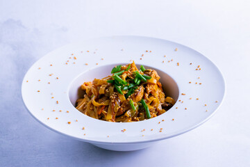 Tasty chicken noodles in a white plate isolated on white close up.