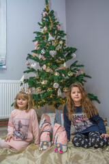 Obraz na płótnie Canvas Little girls next to the Christmas tree