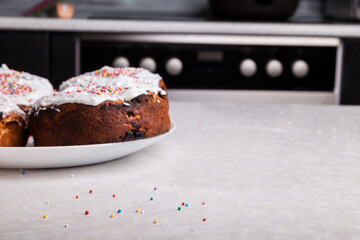 Close-up of fresh baked goods against backdrop home cooking made from curd dough under layer white glaze - beaten egg whites with sugar, decorated with multicolored round confetti scattered on table.