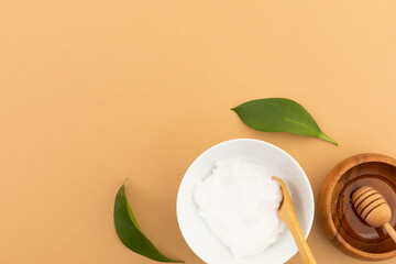 Bowls with yoghurt and dressing on yellow background
