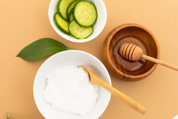 Bowls with yoghurt, cucumber and dressing on yellow background