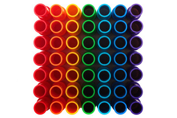 Rainbow colored plastic pipes isolated against white background