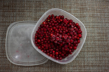 frozen food, frozen lingonberries. frozen lingonberries in a container. preservation of vitamins