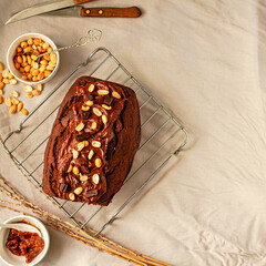Chocolate Brownies cake with nuts and caramel frosting on wire rack on a light linen cloth. Top view