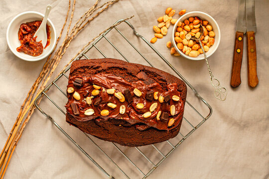 Chocolate Brownies cake with nuts and caramel frosting on wire rack on a light linen cloth. Top view.Christmas baking goods concept