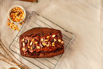 Chocolate Brownies cake with nuts and caramel frosting on wire rack on a light linen cloth. Top view