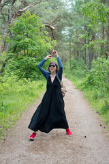 Woman dancing with headphones in the forest