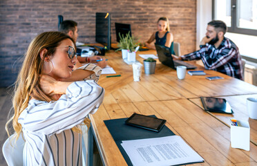 Businesswoman with cervical pain massaging her neck
