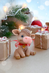 Greeting holiday card with cute toy calf and gifts on festival background. Chinese new year. Symbol 2021. .