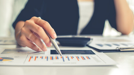 Financial Businesswomen analyze the graph of the company's performance to create profits and...