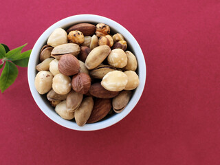 Mixed nuts in a bowl, top view, color background