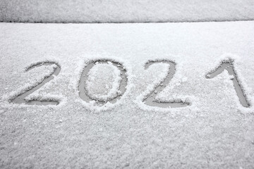 2021 is written on the windshield of the car, in the snow. New Year. Winter.