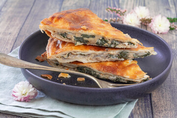 Parts de feuilleté aux épinards et pois-chiche dans une assiette bleue