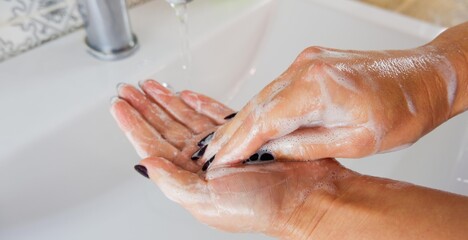 Fototapeta premium Partial view of woman washing hands at home.