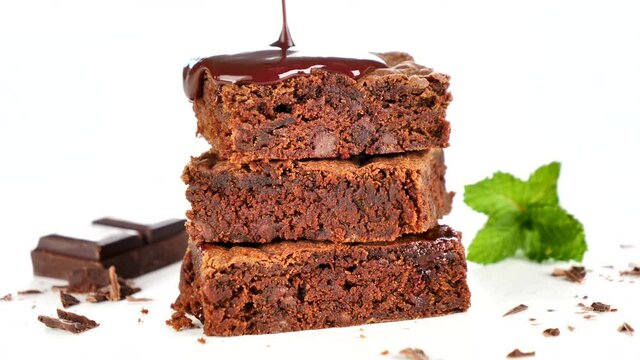 chocolate sauce pouring on stack of chocolate cake isolated on white backgrou,nd