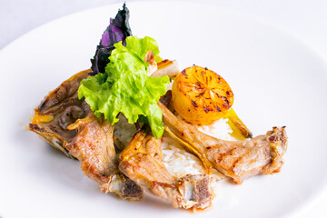 Delicious grilled entrecote with lemon isolated in white plate.