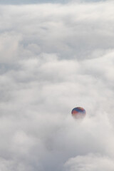 Red and blue hot air balloon in the clouds