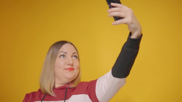 A woman takes pictures of herself on the phone