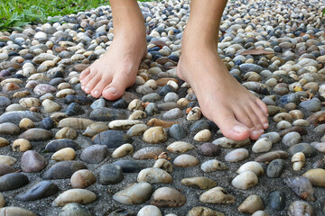 Cropped image woman feet walking on cobble pavement, healthy lifestyle, reflexology
