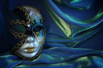 Photo of elegant and delicate Venetian mask over blue dark silk background