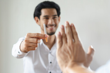 Close up hands of person refusing to smoke cigarette.