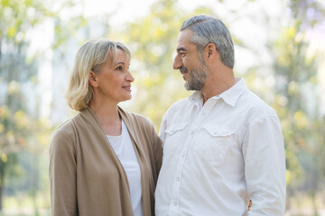 Elderly couple lifestyle concept. Husband and wife looking at each other face nature background