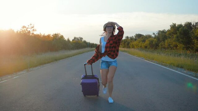 Traveler woman with suitcase on road to travel. Concept of travel.