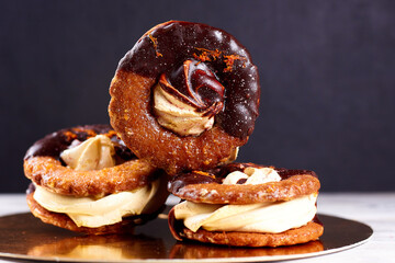 Three homemade chocolate covered marshmallow crackers (s'more ) on a round gold-plated stand plate